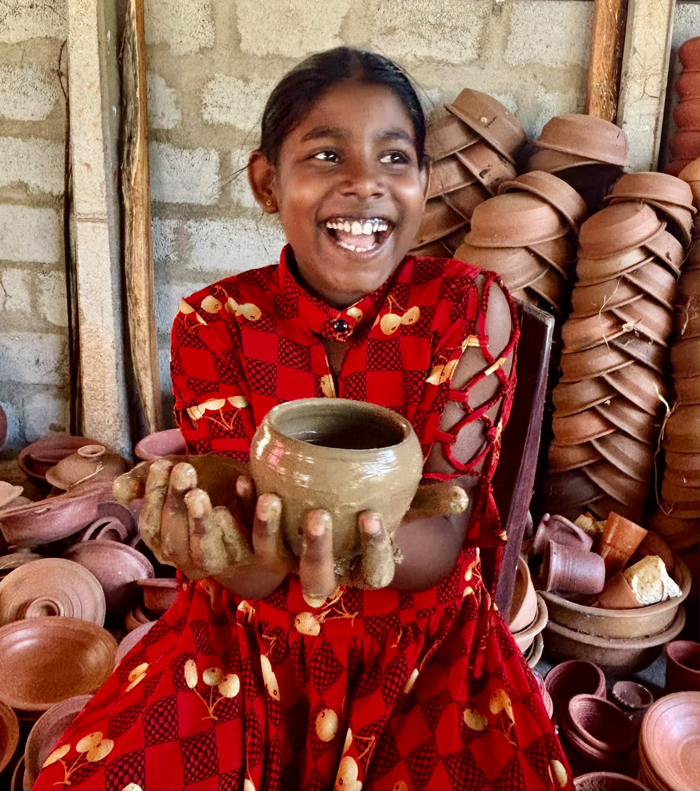 A young visitor proudly holding the pot she made at Hambu Café's pottery workshop